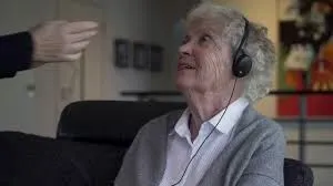 An elderly woman wearing a headset.