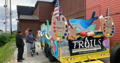 A parade float decorated in an undersea theme. The float has multiple signs promoting the TRAILS program.